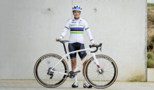 Cyclist wearing cycling clothes holding his white bicycle