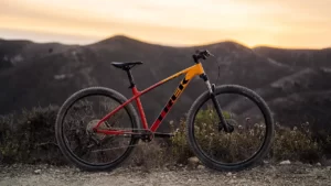 A red and yellow mountain bike , with a mountain range in the background. The bike is a Trek Marlin 7 model.