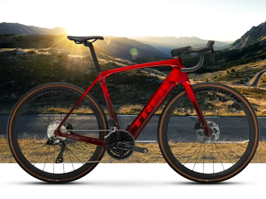 A side view of a red electric bike, showcasing its sleek carbon frame and integrated motor.