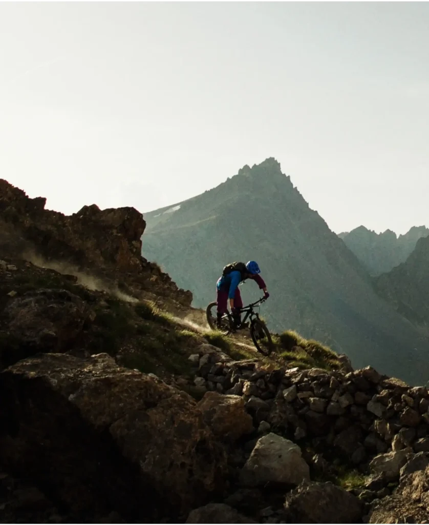 A mountain biker rides down a rocky slope