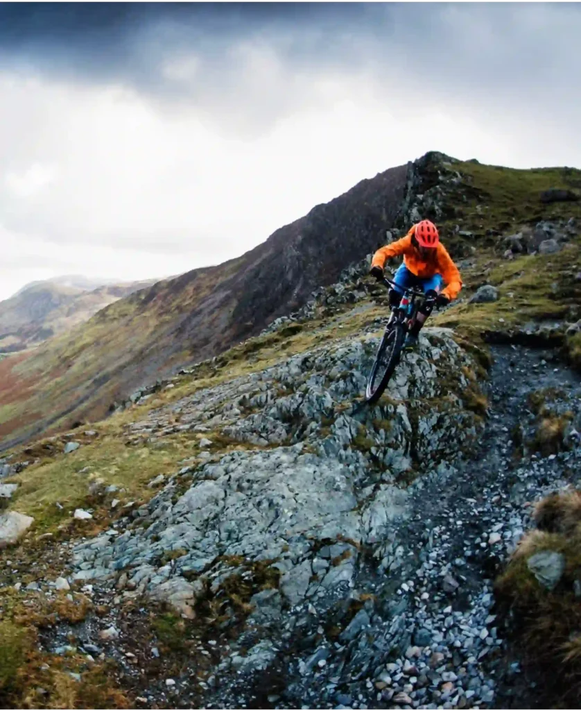 A mountain biker rides down a rocky slope