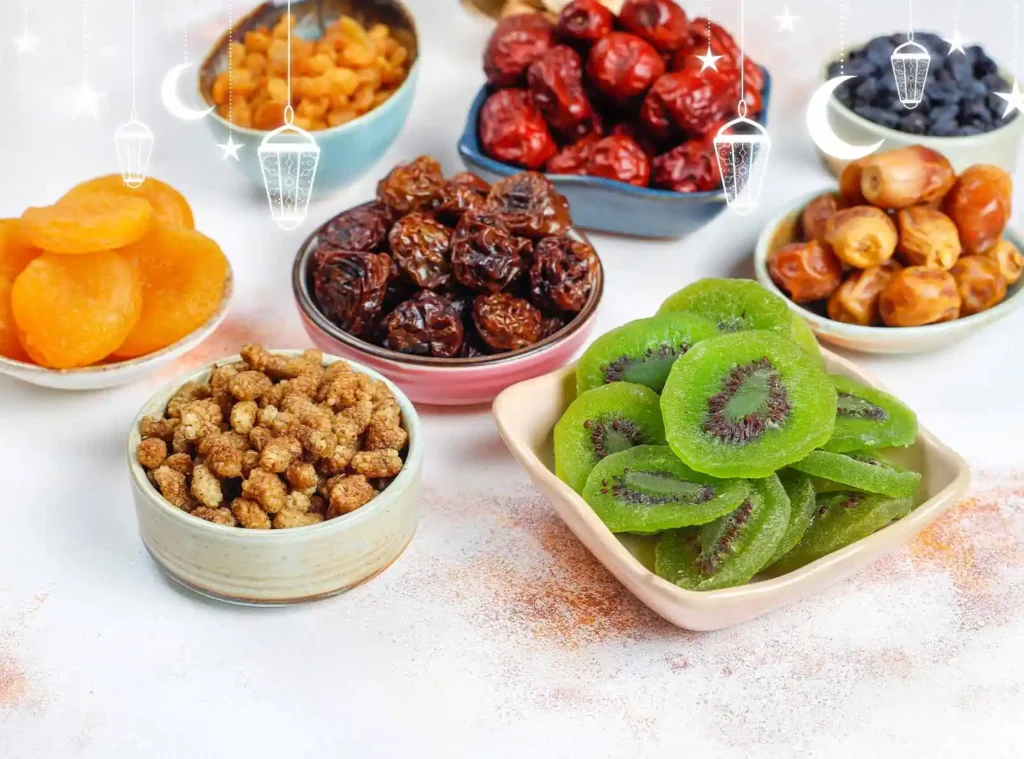 An assortment of dried fruits in colorful bowls, including apricots, raisins, berries, dates, kiwi, and nuts.