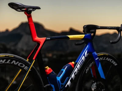 A Trek Project One multi-colored road bike is pictured in a mountainous area. The bike is equipped with professional-grade components.