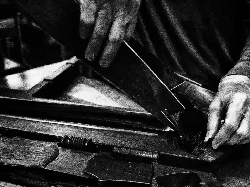 The image shows a person's hand working on a bicycle component, which is likely a frame made of carbon fiber.